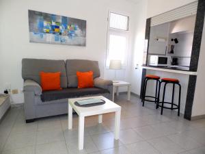 厄尔梅达诺Apartamentos Medano - Playa Grande的客厅配有沙发和桌子