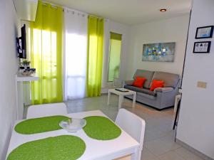 厄尔梅达诺Apartamentos Medano - Playa Grande的客厅配有桌子和沙发