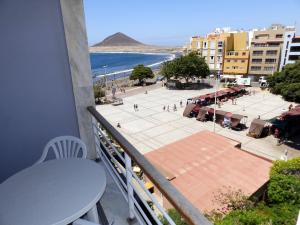 厄尔梅达诺Apartamentos Medano - Playa Grande的阳台配有桌子,享有海滩美景