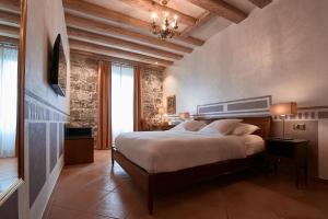 日内瓦德爱里维酒店的一间卧室设有一张大床和石墙