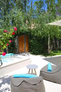 科托尔阿尔奇马酒店的庭院配有两把椅子、一张桌子和玫瑰