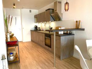 沙博伊茨Studio mit Panorama-Meerblick und direkter Strandlage in Scharbeutz的厨房配有不锈钢用具,铺有木地板