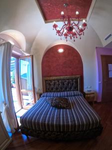 Rocca MassimaLocanda Pinocchio的一间卧室配有一张大床和一个吊灯。