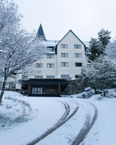 乌斯怀亚乌斯怀亚拉斯哈雅诗度假酒店的建筑物前的一条有雪覆盖的道路