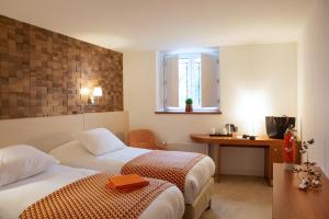 梧玖Hotel Le Clos De La Vouge的酒店客房配有两张床和一张书桌