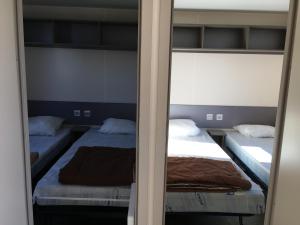 Bec-de-MortagneMobilhome avec vue sur étang的一间卧室配有两张床和镜子