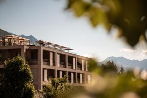 纳图尔诺Sonnen Resort的一座带窗户的建筑,背景是群山