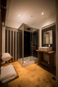 马希库Modern & Recycled Guest House的一间带玻璃淋浴和水槽的浴室
