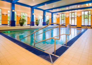 卡罗维发利Spa Hotel Imperial的蓝色柱子建筑中的游泳池