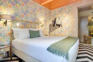波尔图Vila na Praia Foz Luxury Apartments的卧室配有白色的床和色彩缤纷的壁纸