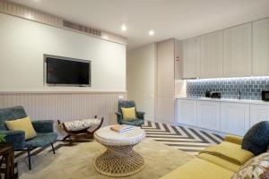 波尔图Vila na Praia Foz Luxury Apartments的客厅配有沙发、椅子和电视