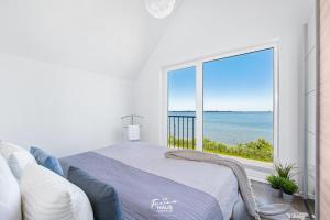 奥尔本尼兹Port 55的一间卧室配有一张床,享有海景