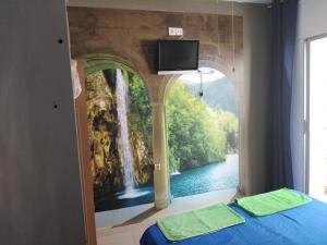 滨海托萨Hostal Sant Jordi的一间卧室,配有瀑布画