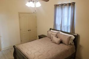 哈蒙德Villa 8的卧室配有带枕头的床铺和窗户。