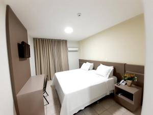 东普里马韦拉Agulhon Hotel的酒店客房设有白色的床和电视。