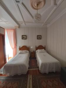圣塞瓦斯蒂安罗雷亚旅馆的一间卧室配有两张床和吊灯。