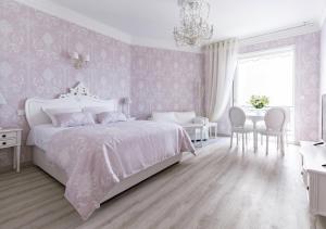 戛纳Palais Miramar Imperial Croisette的卧室配有白色的床和桌椅