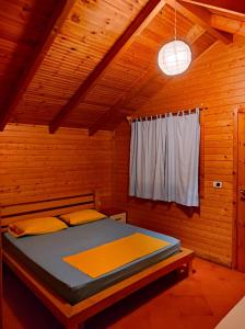 德尔米Guesthouse Vila Druri Dhermi的木制客房内的一间卧室,配有一张床