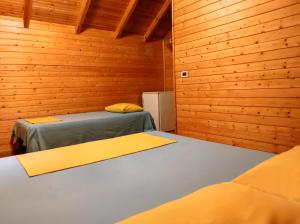 德尔米Guesthouse Vila Druri Dhermi的木墙客房的两张床
