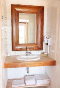 卡布里老城堡客栈的浴室配有带镜子的盥洗盆和毛巾