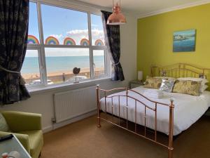 锡顿Mariners Hotel的一间卧室配有一张床,享有海滩美景