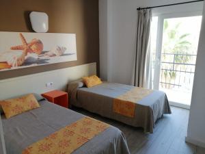 埃尔阿雷纳尔Apartamentos Arcadio的酒店客房设有两张床和窗户。