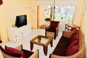 伊斯塔帕VILLA PARA 5 Personas 4 adultos y 1 Menor En HOTEL TSORO IXTAPA WIFI GRATIS的客厅配有沙发、椅子和电视