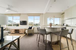 悉尼Harbourside #76的厨房以及带桌椅的起居室。