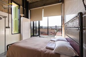 怡保Belakang KongHeng By DreamScape的一张位于带大窗户的房间内的床铺