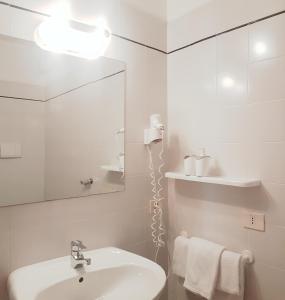 托尔博莱Casa Sandra Bertolini Appartamenti的白色的浴室设有水槽和镜子