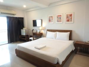 莱卡邦素万那普机场象牙酒店的卧室配有一张白色大床和一张书桌