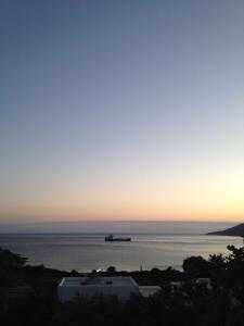 圣彼得罗斯Villa Maniati Studios的日落时分在海洋中的集装箱船