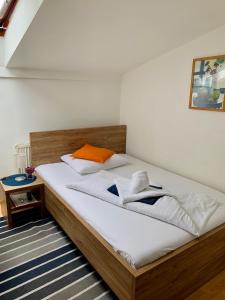 布拉迪斯拉发奥伦酒店的一间卧室配有带白色床单和橙色枕头的床