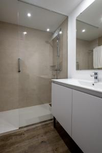 奇克拉纳－德拉弗龙特拉沙丘公寓式酒店的带淋浴和盥洗盆的白色浴室