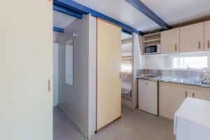 坎佩略邦索尔露营酒店的厨房配有白色橱柜和水槽