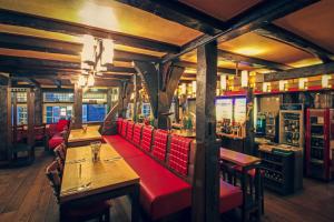 哈廷根Zur alten Krone的一间餐厅,房间内设有桌子和红色的隔间
