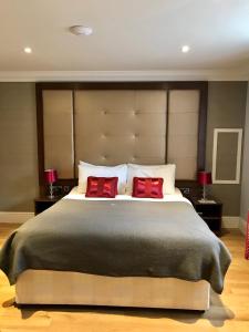 剑桥Lensfield Hotel的一间卧室配有一张大床和两个红色枕头
