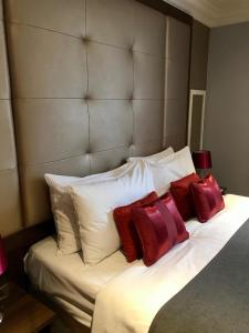 剑桥Lensfield Hotel的一张带红色和白色枕头的床