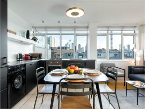 伦敦D8 - Hoxton Square Penthouse的厨房以及用餐室,配有带水果的桌子。