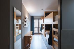 巴塞罗那耶巴塞罗那旅舍的一间设有木制双层床的客房和一间卧室