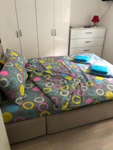 克鲁舍瓦茨Sunce的一间卧室配有一张带色彩缤纷的被子和枕头的床。