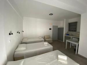 迈洛波塔斯深蓝客房和公寓公寓式酒店的白色的客厅配有两张床和一张桌子
