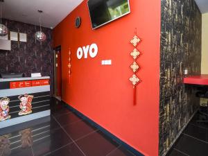 米里OYO 89301 Ys Inn的餐厅的红色墙,上面有莫氏标志