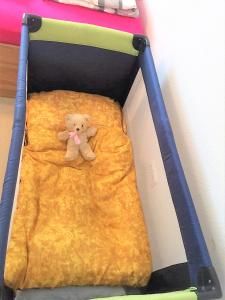 SchmidtFerien Wohnung in der Eifel in Nideggen-Schmidt的一只泰迪熊躺在婴儿床的床上