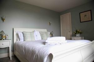 科夫堡Mortons Manor的一间卧室配有带白色床单和枕头的床。