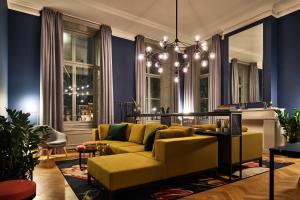 海牙Staybridge Suites The Hague - Parliament, an IHG Hotel的客厅设有黄色沙发和蓝色的墙壁。