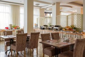 敖德萨阿卡迪亚酒店的一间带桌椅的用餐室和一间餐厅
