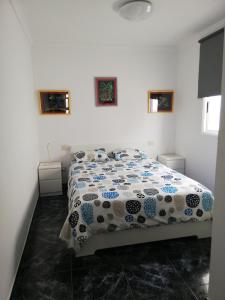 阿里纳加Sun and Sea House 3 Rooms & Wifi的一间卧室配有一张带蓝色和白色棉被的床