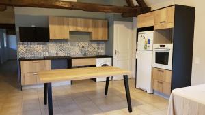 Flacey-en-Bresse多玛尼度假屋的厨房配有木桌和白色冰箱。