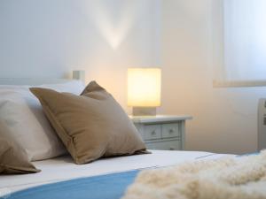 奥尔比亚Villa Miriam - Klodge的一张带枕头的床和一张带台灯的桌子
